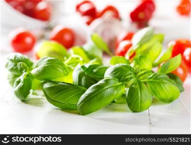 fresh green basil with cherry tomatoes on wooden table