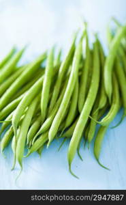 fresh green beans over blue