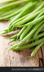fresh green beans over wooden background