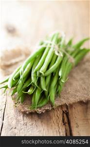 fresh green beans over wooden background