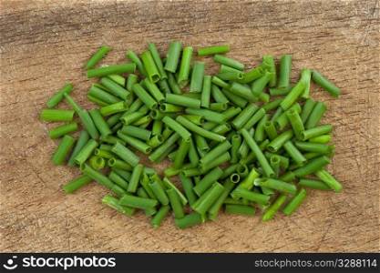 fresh green chives chopped on an old wooden cutting board