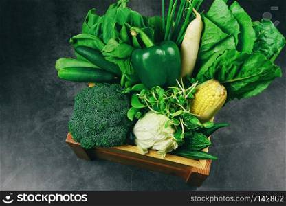 Fresh green fruit and green vegetables mixed in wooden box at market , top view various for healthy food vegan cook / Healthy food selection clean eating for heart life cholesterol diet health concept