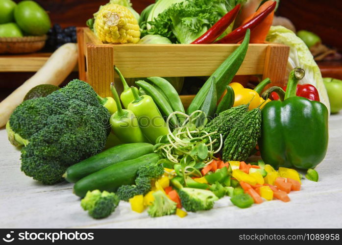 Fresh green fruit and green vegetables mixed in wooden box for sale at market , top view various for healthy food vegan cook / Harvest vegetables healthy food selection clean eating health concept