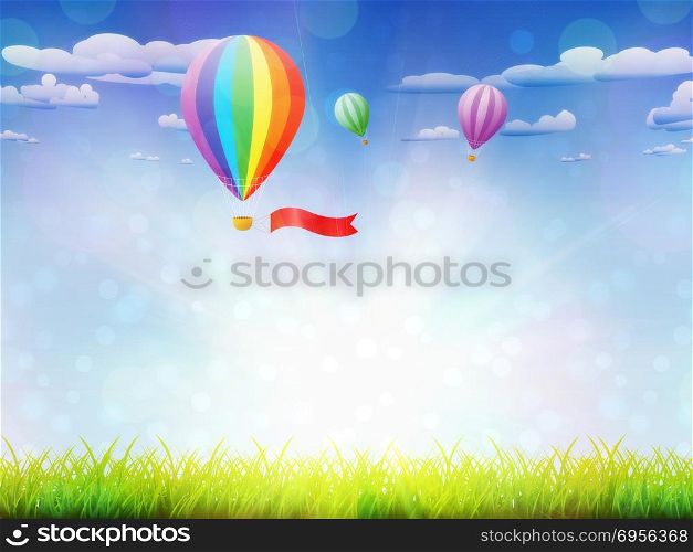 Fresh green grass and hot air balloons in the sky background.. Hot air balloons over grass field