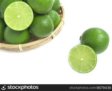 fresh green lime in the bamboo basket isolated on white background.