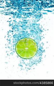 Fresh green lime in the clear water on white background.