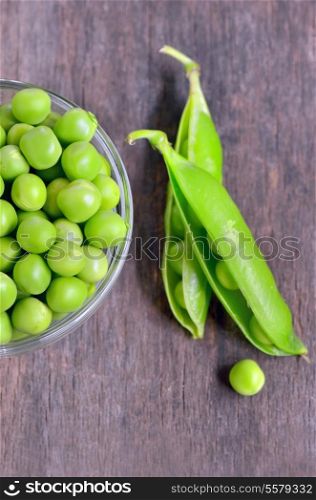 Fresh green pea pod on old wooden background
