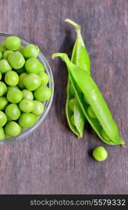 Fresh green pea pod on old wooden background