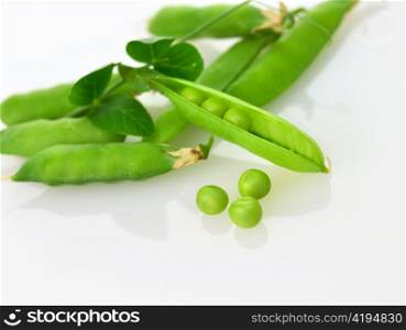 Fresh green pea pods and peas on white background.