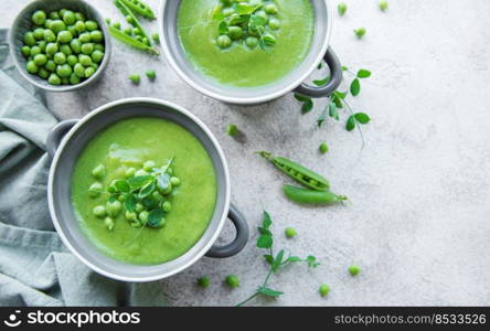 Fresh green pea soup bowl on gray concrete background