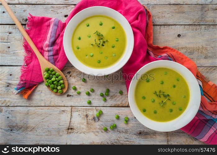 Fresh green pea soup with pea seeds. Cream soup of green peas. A delicious lunch in a rustic style