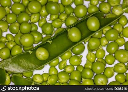 Fresh green peas closeup on a marble backround