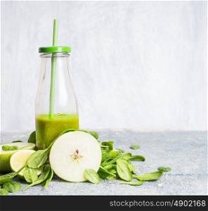 Fresh green smoothie in bottle with apple and spinach on light background, front view. Healthy, diet or detox beverage concept