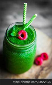 Fresh green smoothie on rustic wooden background