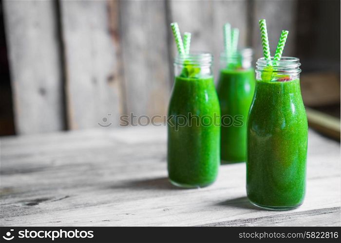 Fresh green smoothie on rustic wooden background