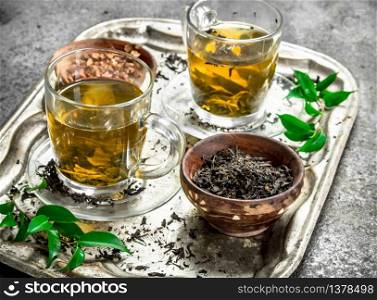 Fresh green tea on a steel tray. On a rustic background.. Fresh green tea on a steel tray.