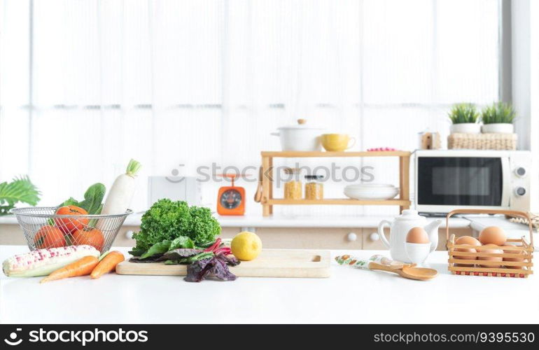 Fresh green vegetable and yellow lemon placed on cutting board, tomatoes, white radish, cos salad in basket, carrots, corn, eggs in egg stand and basket on table. Healthy food in home kitchen