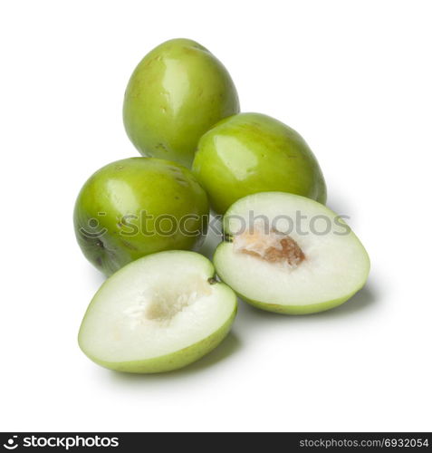 Fresh green whole and half Ambarella fruit with a fibrous pit on white background