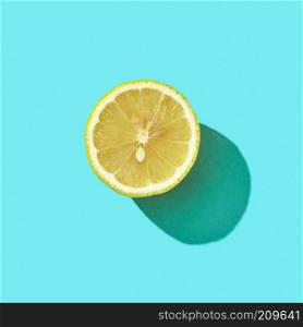 Fresh half organic lemon on blue background with reflection of shadows and space for text. Ingredient for mojito. Top view. Half a juicy lemon on a blue background with shadow and copy space. Ingredient for drink. Top view
