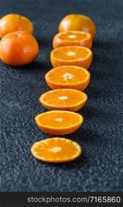 Fresh halved tangerines on black background