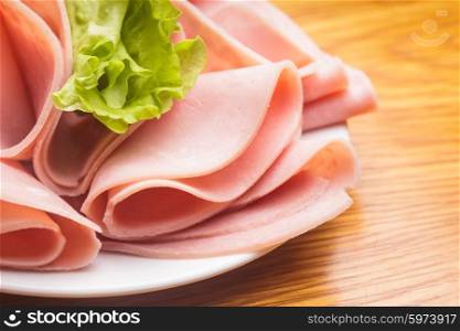 Fresh ham slices with lattuce and cherry tomato on the plate. The Ham slices