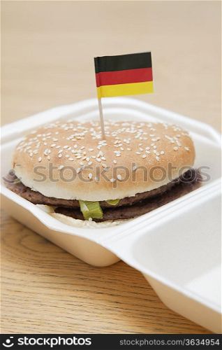 Fresh hamburger with German flag decoration on wooden surface