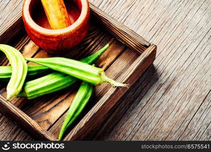 Fresh harvest raw green organic okra in a wooden box.Vegetarianism. Raw green organic okra