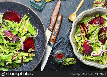 Fresh healthy dandelion, sorrel and beetroot salad on stone table. Spring greens and beetroot salad,mixed herbs
