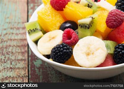 fresh healthy fruit salad on wooden background