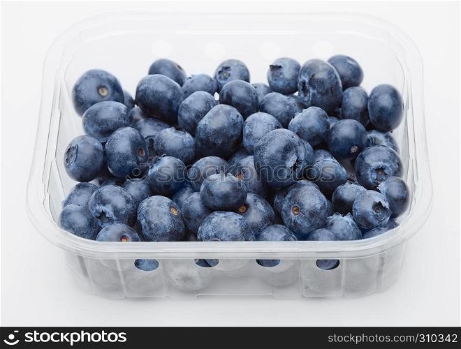 Fresh healthy organic blueberry in plastic container on white background