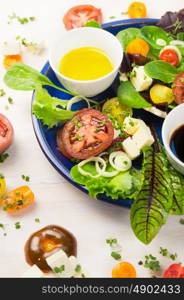 Fresh healthy salad with tomatoes, herbs, feta and oil