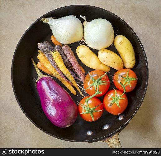 Fresh healthy vegetables ready for roasting in a deep black pan