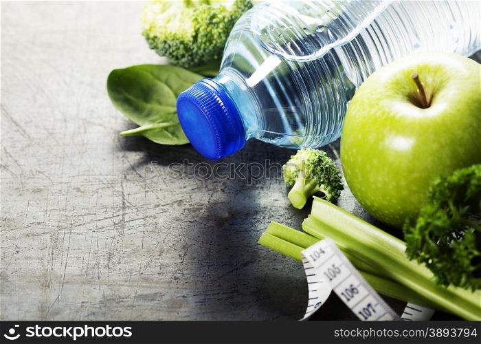 Fresh healthy vegetables, water and measuring tape. Health, sport and diet concept