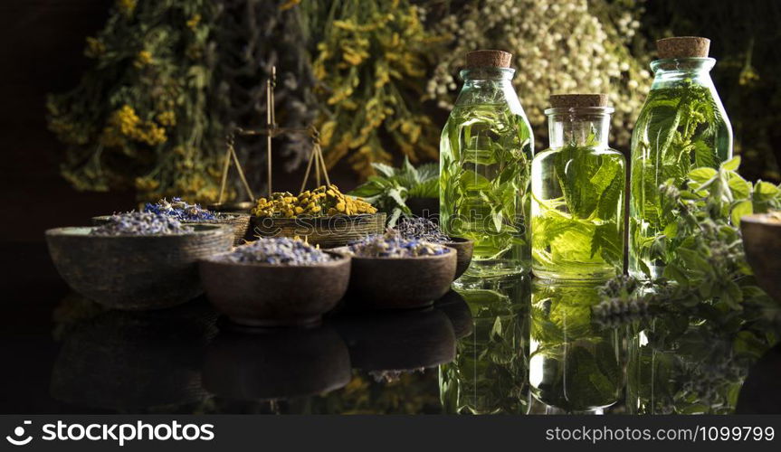 Fresh herbs and oils, wooden table background