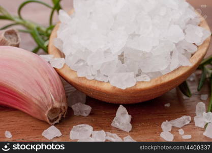 Fresh herbs and salt spoon on vintage wooden background. Shallow focus.