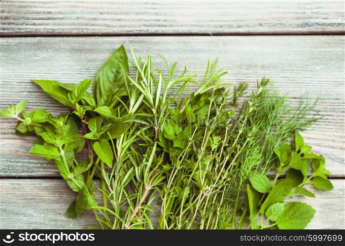 Fresh herbs on the wooden background with copy text. The Fresh herbs