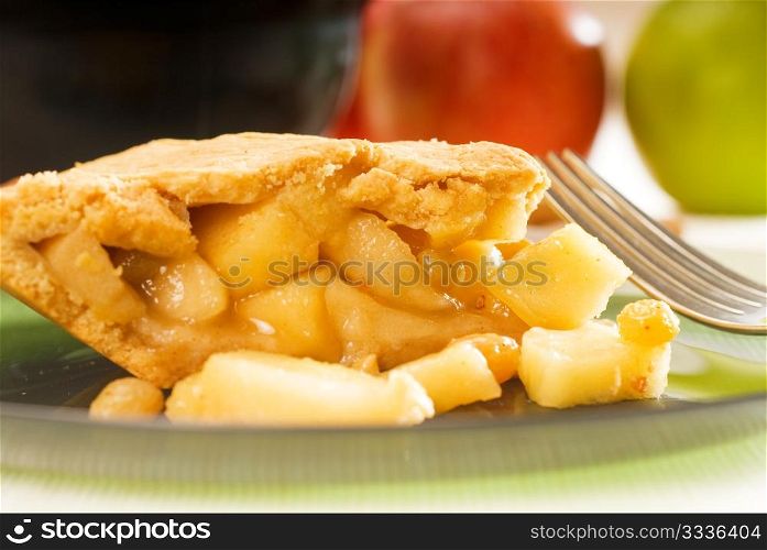 fresh homemade apple pie over green glass dish macro colseup eating with fork
