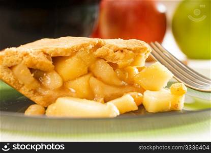 fresh homemade apple pie over green glass dish macro colseup eating with fork