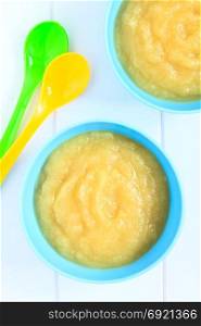 Fresh homemade apple sauce in bowls with colorful spoons, photographed overhead with natural light (Selective Focus, Focus on the apple sauce in the bowls). Apple Sauce