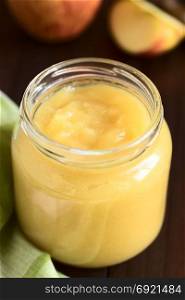 Fresh homemade apple sauce in glass jar, photographed with natural light (Selective Focus, Focus one third into the apple sauce in the jar). Apple Sauce in Jar