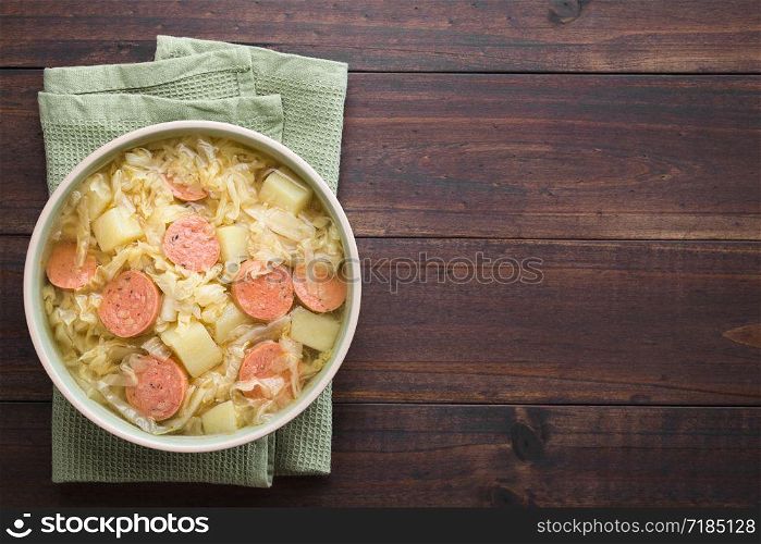 Fresh homemade cabbage, potato and sausage stew in bowl, photographed overhead with copy space on the right side (Selective Focus, Focus on the dish). Cabbage, Potato and Sausage Stew