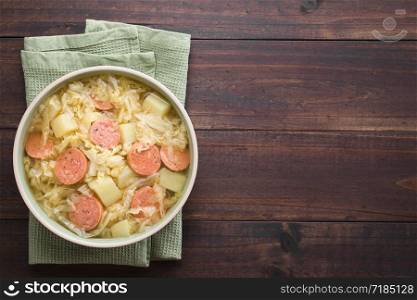 Fresh homemade cabbage, potato and sausage stew in bowl, photographed overhead with copy space on the right side (Selective Focus, Focus on the dish). Cabbage, Potato and Sausage Stew