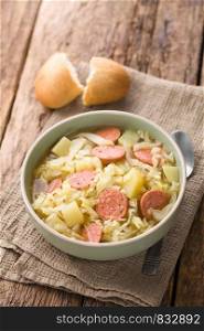 Fresh homemade cabbage, potato and sausage stew in bowl, with bread roll and spoon on the side (Selective Focus, Focus one third into the dish). Cabbage, Potato and Sausage Stew