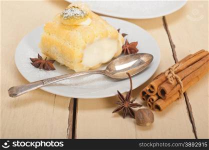 fresh homemade cream roll cake dessert and spices over white rustic wood table