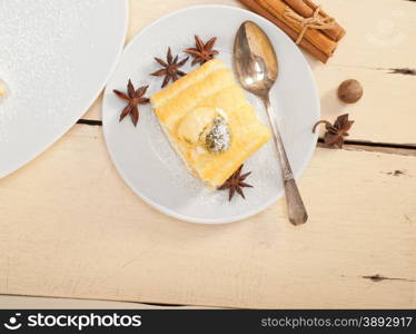 fresh homemade cream roll cake dessert and spices over white rustic wood table