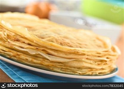 Fresh homemade crepes piled on plate (Selective Focus, Focus on the front of the crepes)