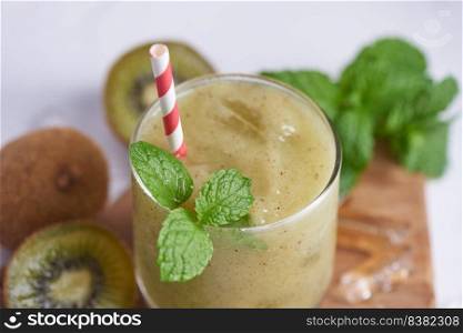 Fresh homemade kiwi smoothies with milk, mint and honey. Healthy organic drink. Close up and selective focus. Freshly blended green fruit, well being and weight loss concept.