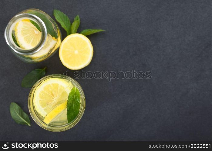 Fresh homemade lemonade with mint leaves, photographed overhead on slate (Selective Focus, Focus on the top of the lemonade). Fresh Lemonade with Mint