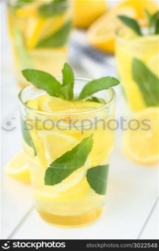 Fresh homemade lemonade with mint leaves (Selective Focus, Focus on the front of the rim of the first glass). Fresh Lemonade with Mint