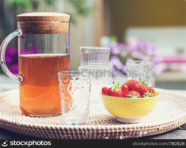 Fresh homemade lemonade with strawberries outdoors on the garden table in the summer colorful. Fresh homemade lemonade with strawberries outdoors on the garden table in the summer